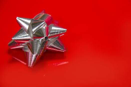 Shiny silver satin ribbon on red background. photo