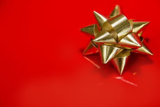 Shiny gold satin ribbon on red background. photo