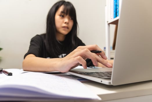 Asian teen girl use computer laptop technology internet online research information social network and education homework on table. photo