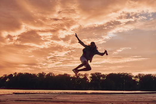 Go wild Young man hovering against dramatic sky while jumping on the pier photo