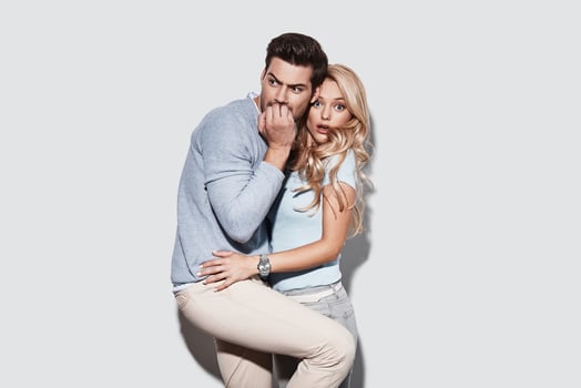 Horror. Terrified young couple making a face while standing against grey background photo