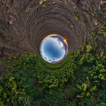 Inversion of little planet transformation of spherical panorama 360 degrees. Spherical abstract aerial view in field with awesome beautiful clouds. Curvature of space. photo