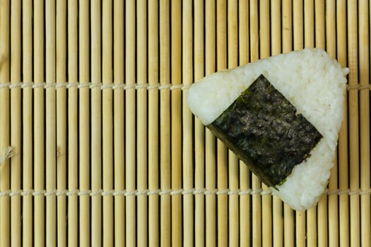The Japanese food Onigiri  white rice formed into triangular or cylindrical shapes and often wrapped in nori. photo
