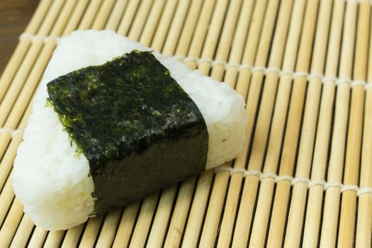 The Japanese food Onigiri  white rice formed into triangular or cylindrical shapes and often wrapped in nori. photo
