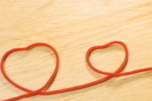 Red rope heart on wood plate valentine content. photo