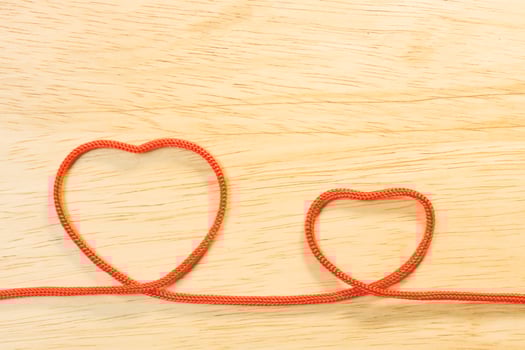 Red rope heart on wood plate valentine content. photo