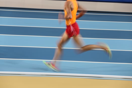 Blured athletes run in track and field photo