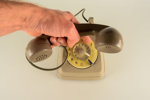 a person holding a telephone with their hand photo