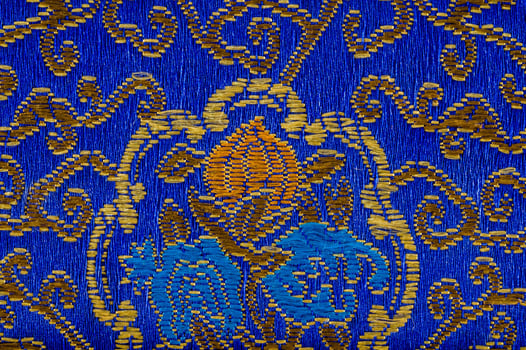 a blue and gold patterned fabric with a floral design photo