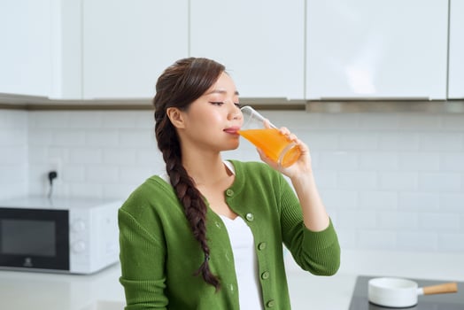 beautiful girl smiling standing hold orange glass juice kitchen photo