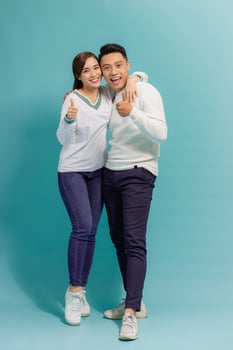 portrait of happy young stylish couple in love having fun in studio isolated on blue background photo