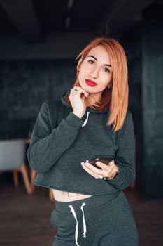 European white redhead woman hold smartphone indoor photo