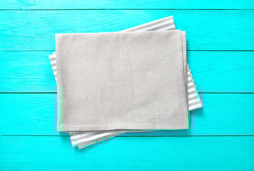 Gray and white striped tablecloth on blue wooden kitchen. Top view and copy space. Mock up photo