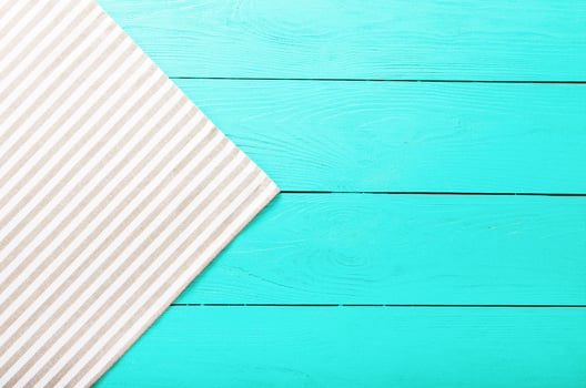 Striped gray and white material on blue wooden background. Top view and copy space. Mock up photo
