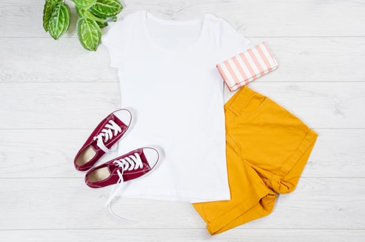 White female t shirt mock up flat lay on wooden background. Top front view t-shirt and copy space. Mockup t-shirt and summertime. Template blank shirt. photo