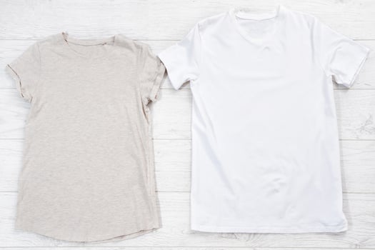 White closeup t shirt mock up flat lay on white wooden background. Male and female shirts. Top view and copy space. Mockup summer t-shirt and summertime. Template blank shirt. photo
