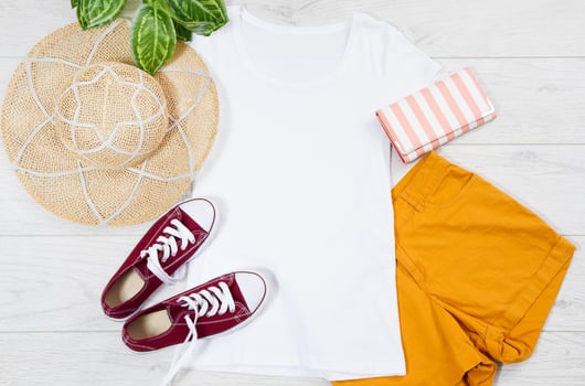 White female t shirt mock up flat lay on wooden background. Top view and copy space. Mockup t-shirt and summertime. Template blank shirt. Hat photo