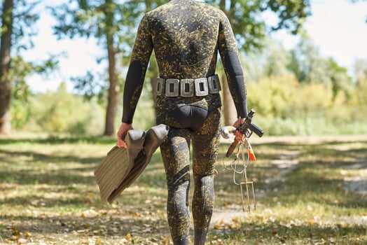 diver in wet suit and flippers with a harpoon shotgun photo