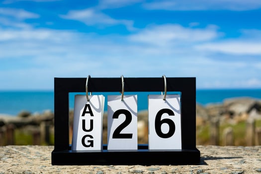 August 26 calendar date text on wooden frame with blurred background of ocean. photo