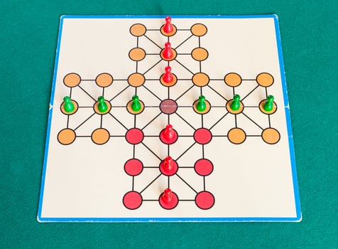 setup of cross solitaire board game on green table photo
