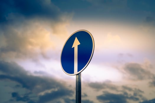 Road sign on the background of the sky with clouds photo