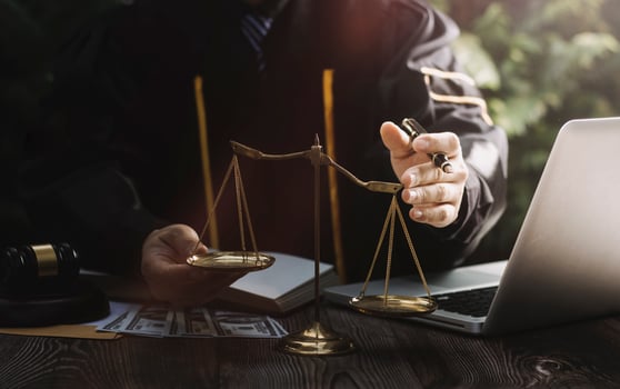 Business and lawyers discussing contract papers with brass scale on desk in office. Law, legal services, advice, justice and law concept picture with film grain effect photo