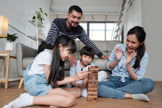 Happy Asian lovely Thai family activity, parents, dad, mum, and children have fun playing and joyful wooden toy blocks together on living room floor, leisure weekend, and domestic wellbeing lifestyle. photo