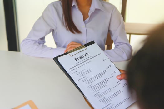 Close-up view of office job interviews with HR personnel holding resume and background checks on applicants with prepared skills. photo