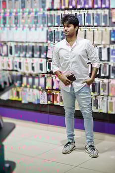 Indian man customer buyer at mobile phone store choose a case for his smartphone. South asian peoples and technologies concept. Cellphone shop. photo
