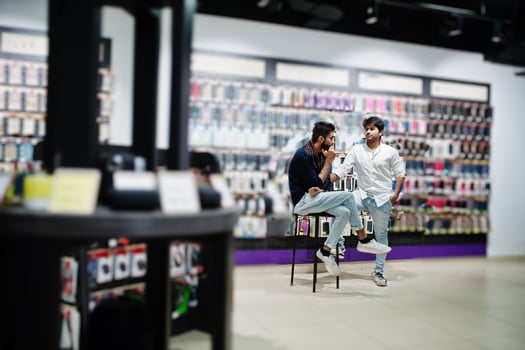 Two indian man customers buyer at mobile phone store choose a case for his smartphone. South asian peoples and technologies concept. Cellphone shop. photo