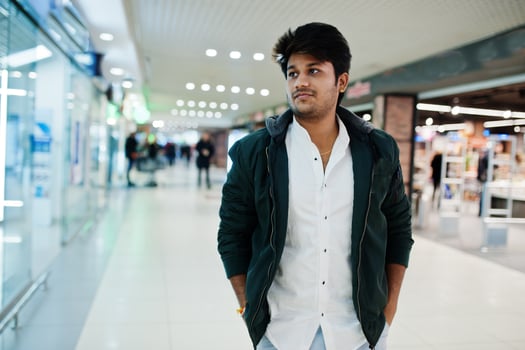Fashionable indian guy at white shirt and jacket posed on mall. Asian man shopping. photo