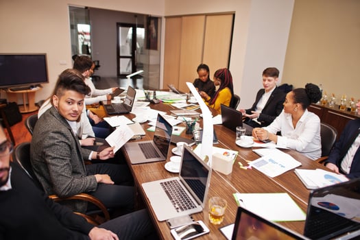 Multiracial business team addressing meeting around boardroom table. photo