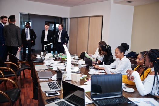 Multiracial business team addressing meeting around boardroom table. photo