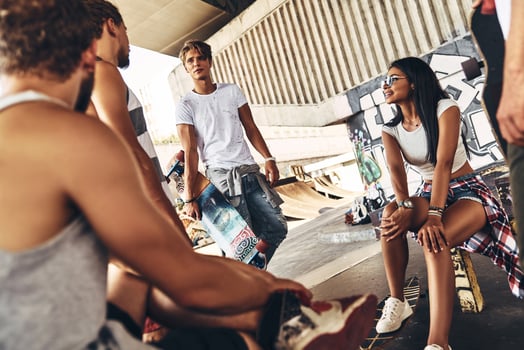 Skate friends forever. Group of young modern people talking while spending time at the skateboard park outdoors photo
