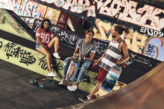 Skate friends forever. Group of young modern people hanging out together while spending time at the skate park outdoors photo