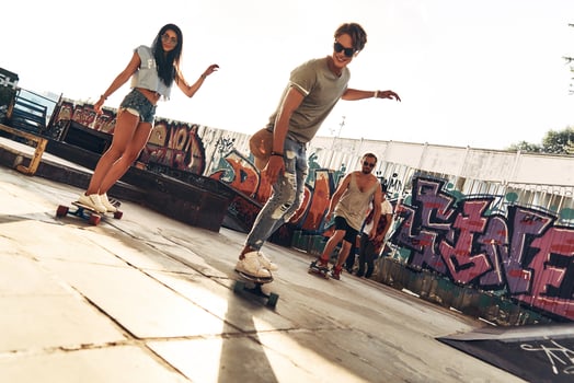 Skating is their life. Full length of young people skateboarding while hanging out at the skate park outdoors photo