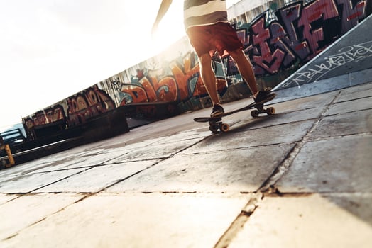 On the move. Close-up of modern young man skateboarding while hanging out at the skate park outdoors photo