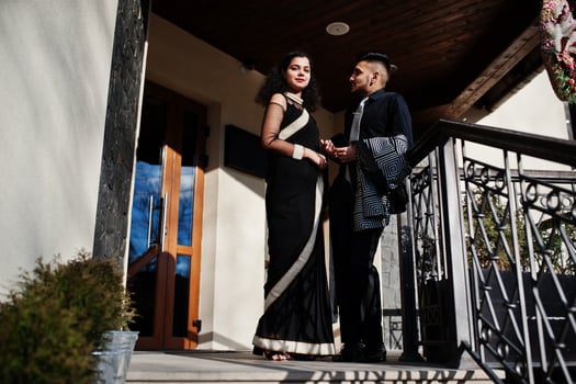 Lovely indian couple in love, wear at saree and elegant suit, posed outdoor terrace on summer sunny day. photo