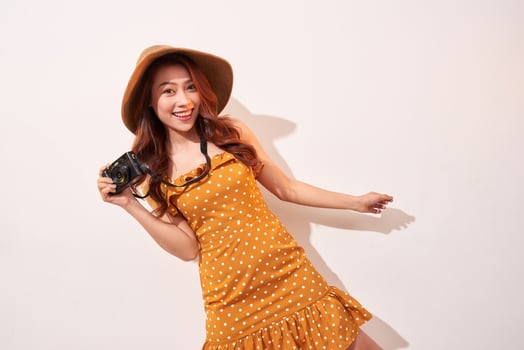 Image of young photographer woman isolated over beige background wall holding camera. photo