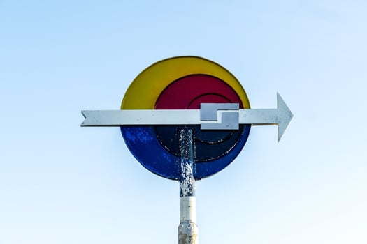 a colorful sign with an arrow pointing to the right photo