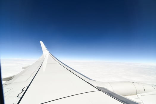 an airplane wing with a blue sky and clouds in the background photo