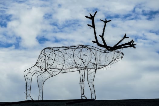 a metal deer sculpture on top of a roof photo