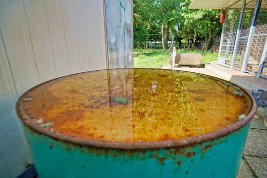 a rusty metal barrel with a yellow substance on it photo