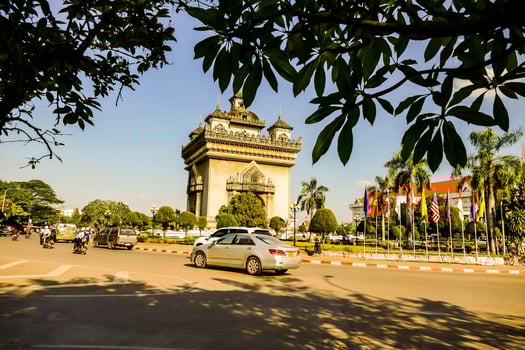 cars driving down the road in front of a pagoda photo