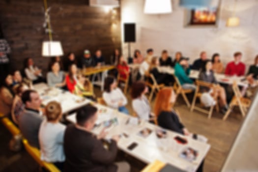 Master class and study concept. Abstract blurred photo of conference or seminar room with speaker on the stage.