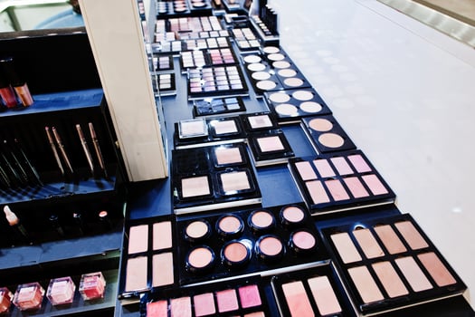 Multicolor lipstick or eye shadow makeup pallette on shelf in the shop. photo