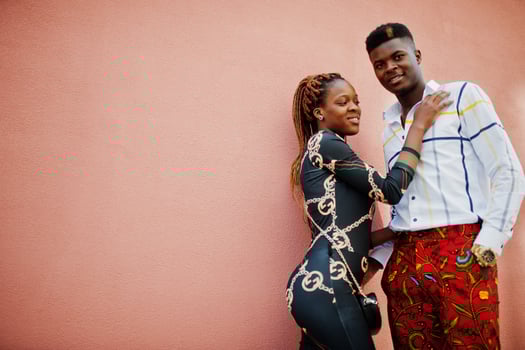 Handsome stylish african american couple posed at street together in love against pink wall. photo