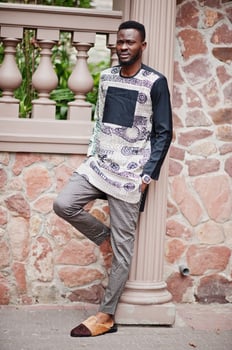 Handsome afro american man wearing traditional clothes in modern city. photo