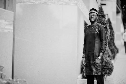 Handsome afro american man wearing traditional clothes, cap and eyeglasses in modern city. photo