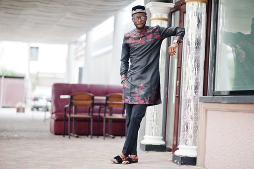 Handsome afro american man wearing traditional clothes, cap and eyeglasses in modern city. photo